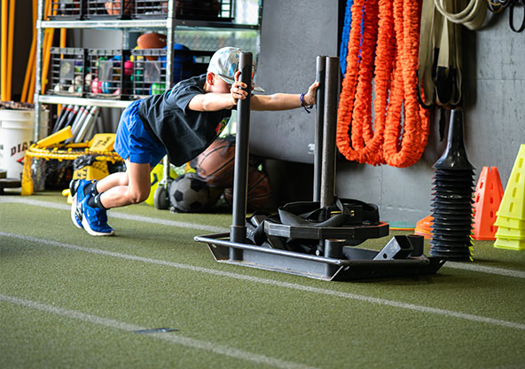 kid pushing weight across floor