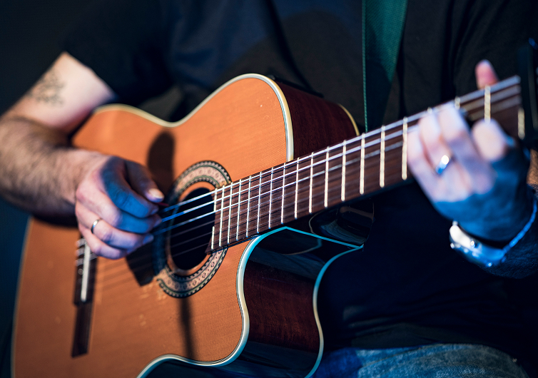 Musician playing guitar - Cancer Events
