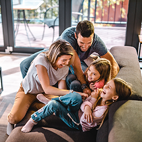 A mom and dad playing with their daughters